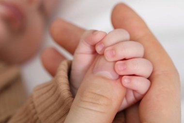 Anne, küçük bebeği evde, yatağında, yakın plan.