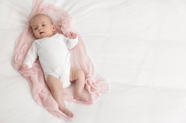 Evdeki yatakta uzanmış şirin küçük bebek, üst manzara. Metin için boşluk