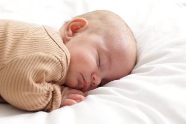 Evdeki yatakta uyuyan tatlı bir bebek.