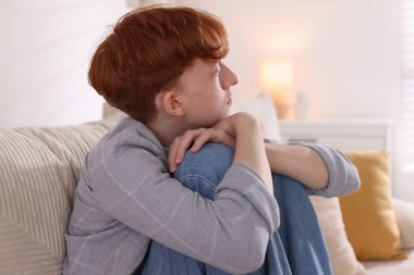 Gençlik sorunları. Evdeki kanepede depresif bir genç çocuk.