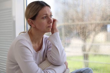 Evdeki pencerenin yanındaki depresif kadın, metin için boşluk