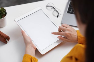 Beyaz masadaki tabletli kadın, yakın plan.