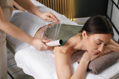 Vücut bakımı gören kadın spa salonunda tedavi görüyor