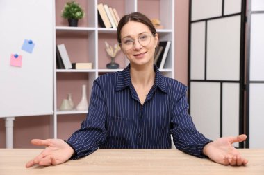 Gülümseyen çevrimiçi hoparlör. İçerideki masada web kamerasından görüntüsü olan webinar.