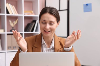 Gülümseyen çevrimiçi hoparlör içeride dizüstü bilgisayarla webinar yayınlıyor