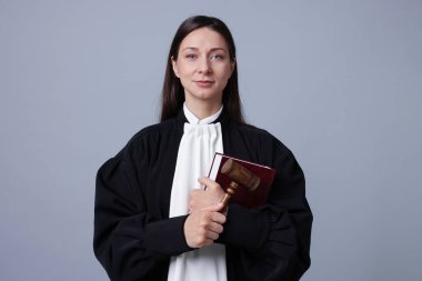 Gri arkaplan üzerine kitap ve çekiçle yargıç