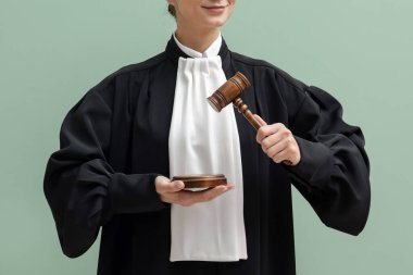 Açık yeşil arkaplanda çekiç ve ses engeli olan hakim, yakın plan