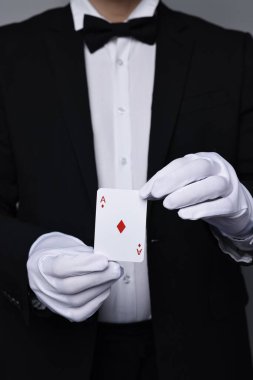 Gri arkaplanda oyun kartı olan bir illüzyonist, yakın plan