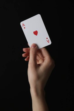 Siyah arka planda iskambil kartı olan kadın, yakın plan