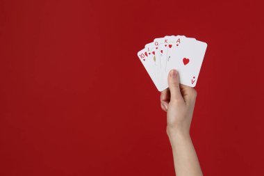 Kırmızı arka planda iskambil oynayan kadın, yakın plan. Metin için boşluk