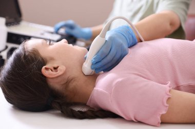 Sonograf, klinikte kızın tiroid bezi ultrason muayenesini yönetiyor.