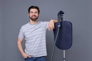 Gri arka planda vapuru olan bir adam.