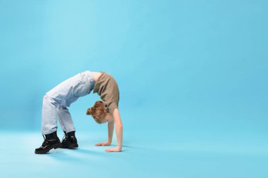 Açık mavi arka planda dans eden şık elbiseli kız, metin için yer var.