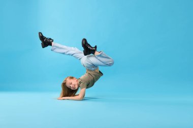 Açık mavi arka planda dans eden şık elbiseli kız, metin için yer var.