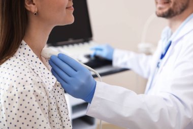 Sonograf klinikte kadının tiroid bezini ultrason taraması yapıyor.