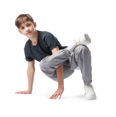 Beyaz arka planda dans eden şık elbiseli bir çocuk.