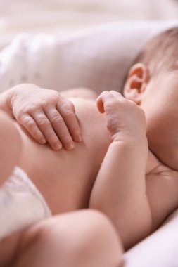 Küçük bebek yatakta uzanıyor, yakın plan.