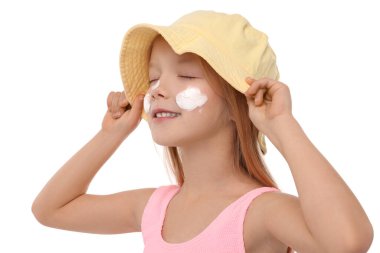 Yanaklarında güneş kremiyle gülümseyen küçük kız beyaz arka planda, yakın plan