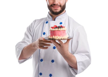 Üniformalı mutlu pastacı elinde beyaz arka planda böğürtlenli kek tutuyor.