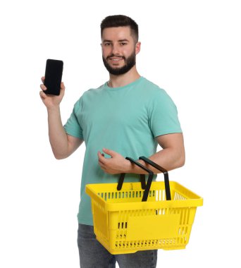 Beyaz arka planda boş alışveriş sepeti ve akıllı telefonu olan bir adam.