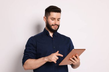 Yakışıklı adam beyaz zemin üzerine tablet kullanma