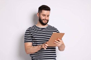 Yakışıklı adam beyaz zemin üzerine tablet kullanma