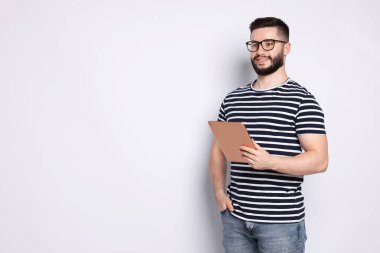 Beyaz arkaplanda tablet kullanan yakışıklı adam, metin için boşluk