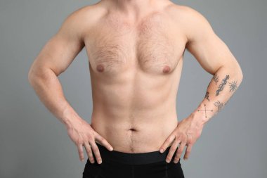Açık gri arka planda kıllı göğüslü genç adam, yakın plan. Epilasyon işlemi