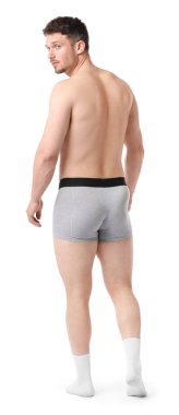 Beyaz arka planda açık gri iç çamaşırlı genç adam.