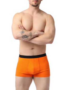 Beyaz arka planda turuncu iç çamaşırlı genç adam, yakın plan.