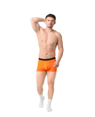 Beyaz arka planda turuncu iç çamaşırlı genç adam.