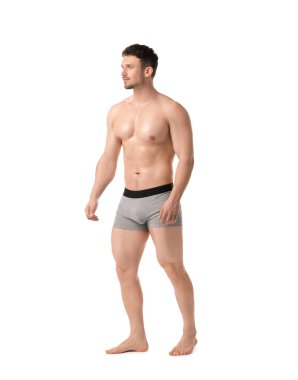 Beyaz arka planda açık gri iç çamaşırlı genç adam.