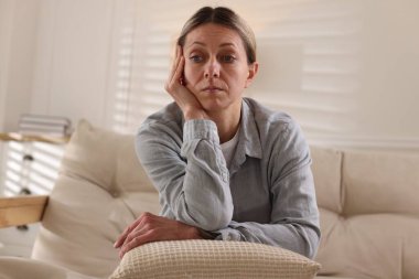 Evdeki kanepede depresyon geçiren bir kadın.