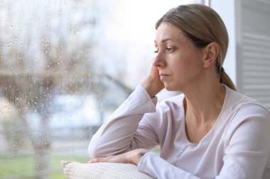 Evdeki pencerenin yanındaki depresif kadın, metin için boşluk