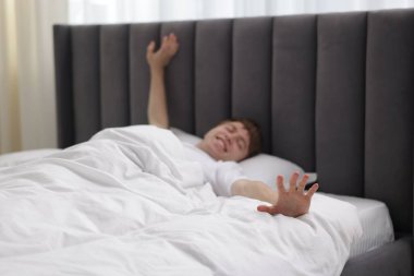 Yatakta uzanan mutlu adam, seçici odaklanma.