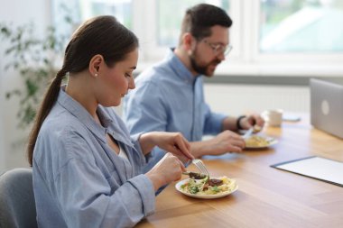 İş arkadaşları öğle arasında yemek yiyor.