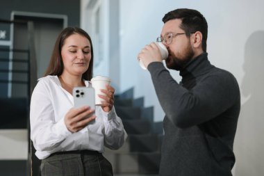 Mesai arkadaşları kahve molası sırasında ofislerinde kahve içerler.