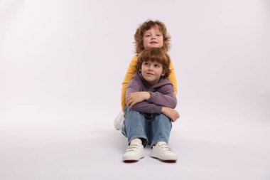 Beyaz arka planda poz veren şirin küçük kardeşler.