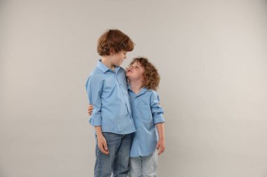 Hafif arka planda kucaklaşan sevimli küçük kardeşler.