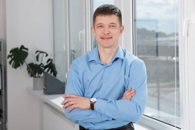 Pencerenin yanındaki yakışıklı adamın portresi.