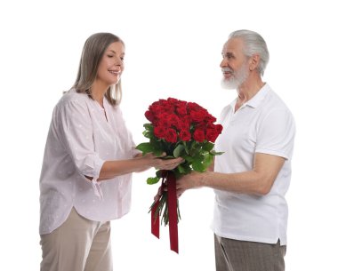 Adam beyaz arka planda mutlu karısına kırmızı gül buketi sunuyor.
