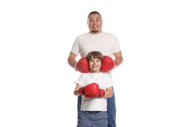 Babası ve oğlu boks eldivenleriyle beyaz arka planda.