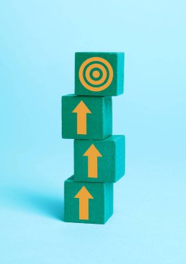 Hedef alınıyor. Yığılmış yeşil küplerle oklar açık mavi arkaplana karşı en üstteki küpü işaret ediyor