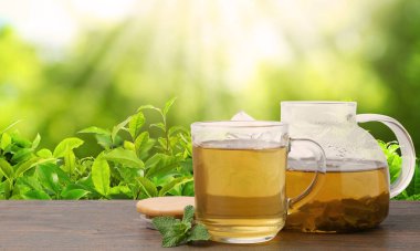 Yeşil çay fincanda ve çaydanlık çay çiftliğinde ahşap masada. Metin için alanı olan pankart tasarımı