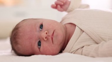 Sevimli yeni doğmuş bebek yatakta uzanıyor, yakın plan.