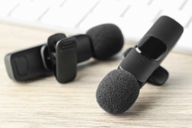 Lavalier mikrofonları ahşap masada, yakın plan. Ses ekipmanları