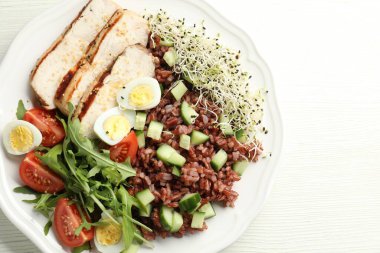 Beyaz ahşap masada kahverengi pirinçli nefis bir salata.