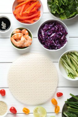 Pirinç kağıt çarşaflar ve beyaz ahşap masa üzerindeki farklı malzemeler.