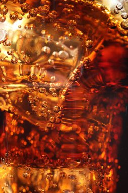 Arkaplan olarak buz küpleriyle kola tazeleniyor, makro görünüm