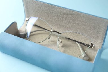 Açık mavi arka planda şık gözlüklü çanta, yakın plan